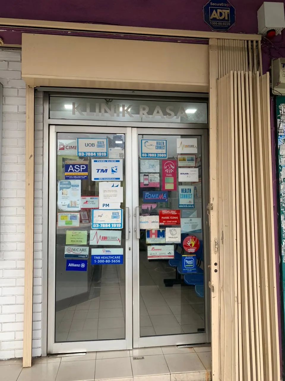 Pintu hadapan Klinik Rasa yang menunjukkan pelekat panel insurans